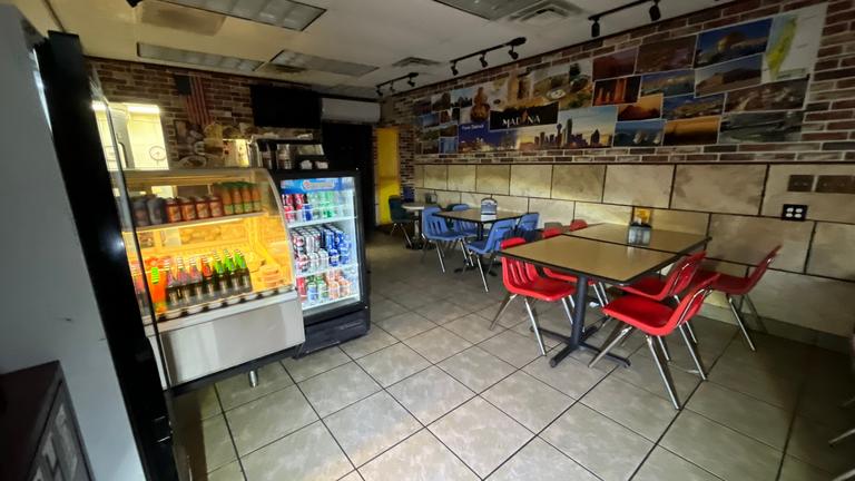 Restaurant dining area with coolers and tables during a cockroach inspection, documenting sanitation and access points in a commercial space in Richardson, Texas.