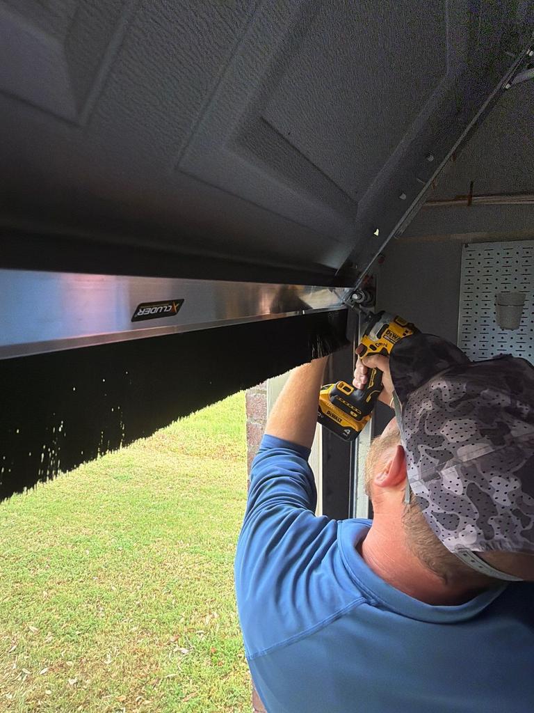 Exclusion work installing a barrier above a garage door in McKinney, Texas.