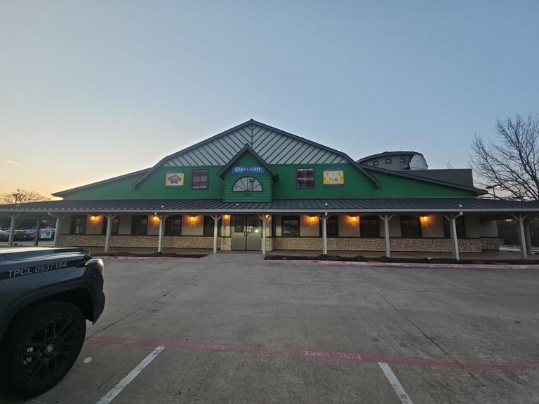 Wide view of a commercial building at dusk, documented during a general pest perimeter inspection of the exterior in Grapevine, Texas.