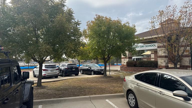 Exterior view of a school parking lot and landscaping being inspected for general pest activity during October in Frisco, Texas.