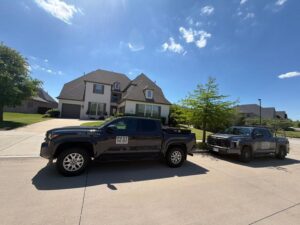 Two Pest Me Off service trucks parked along a residential driveway, indicating a general pest control visit in Prosper, Texas.