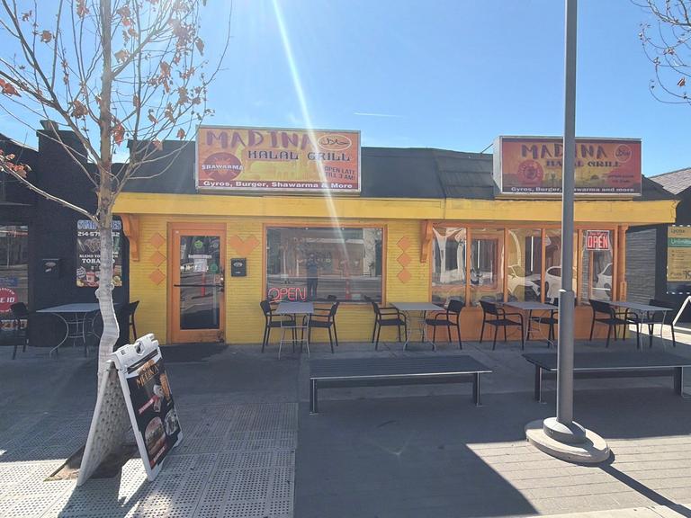 Exterior of a small restaurant with outdoor seating captured during a routine rodent inspection and monitoring service on the front patio in Richardson, Texas.