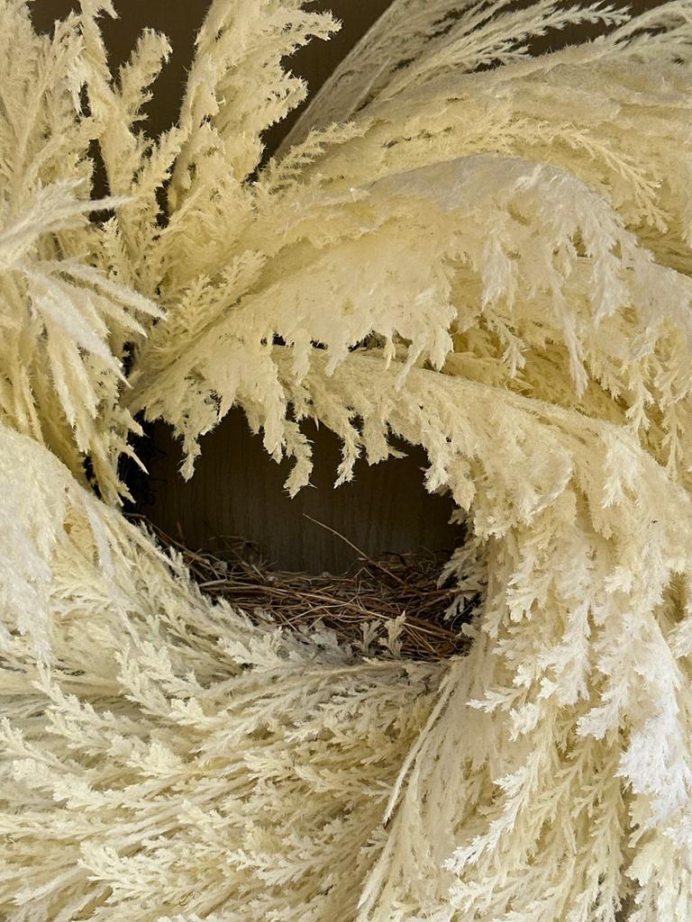 Compact bird nest tucked inside a decorative front-door wreath, noted during a residential pest control inspection in Fairview, Texas.