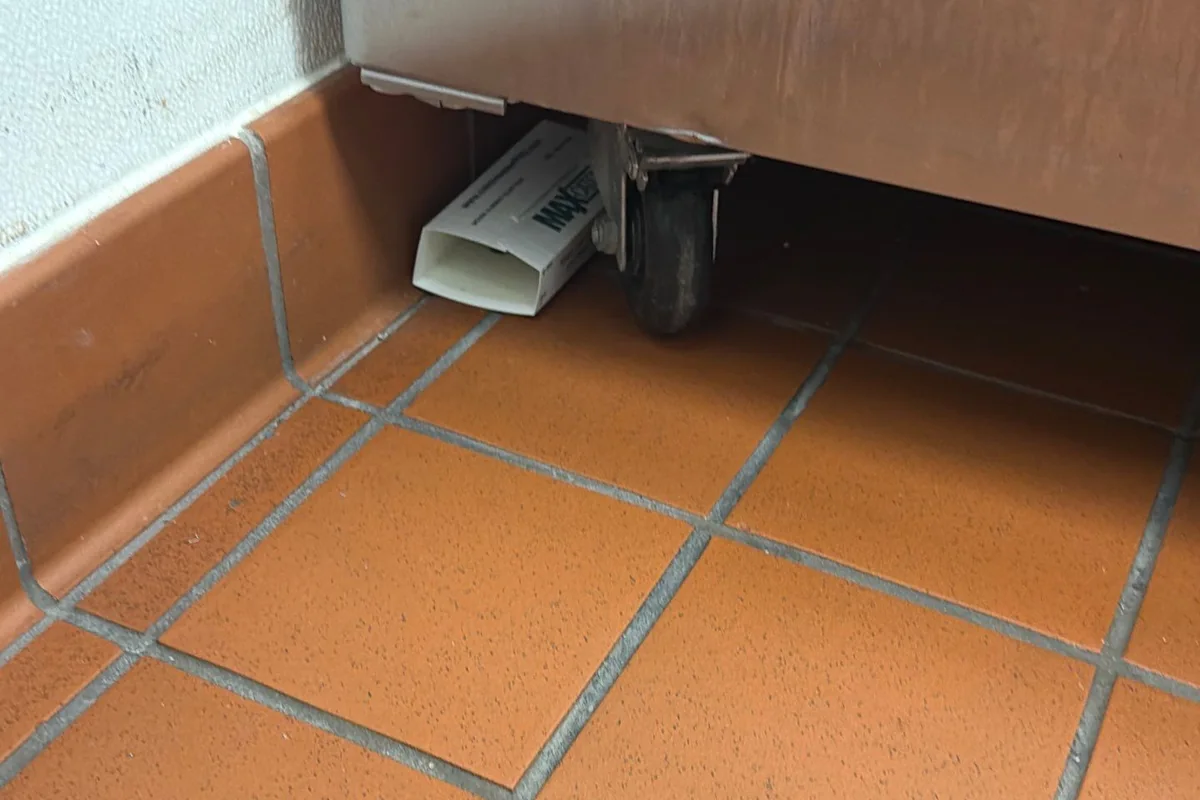 Pest Control The Colony, TX 13 Glue-board monitor catching cockroaches under commercial kitchen equipment on a Pest Me Off job in The Colony, TX