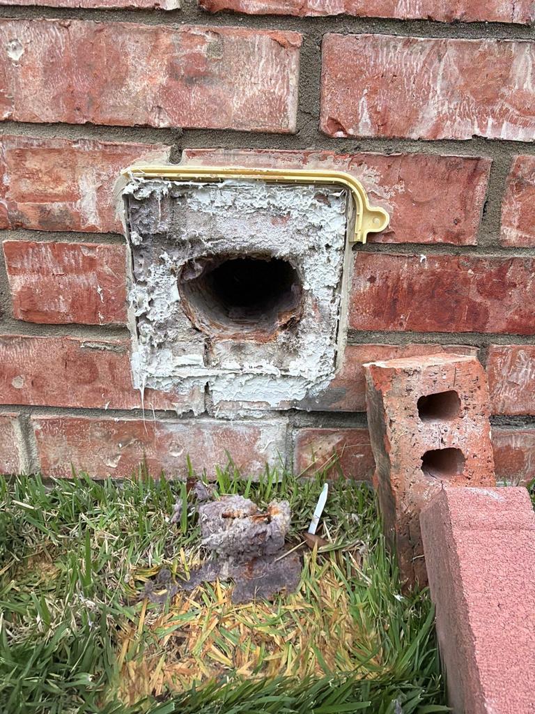 Exclusion work sealing an open hole in a brick wall at a property in Plano, Texas.