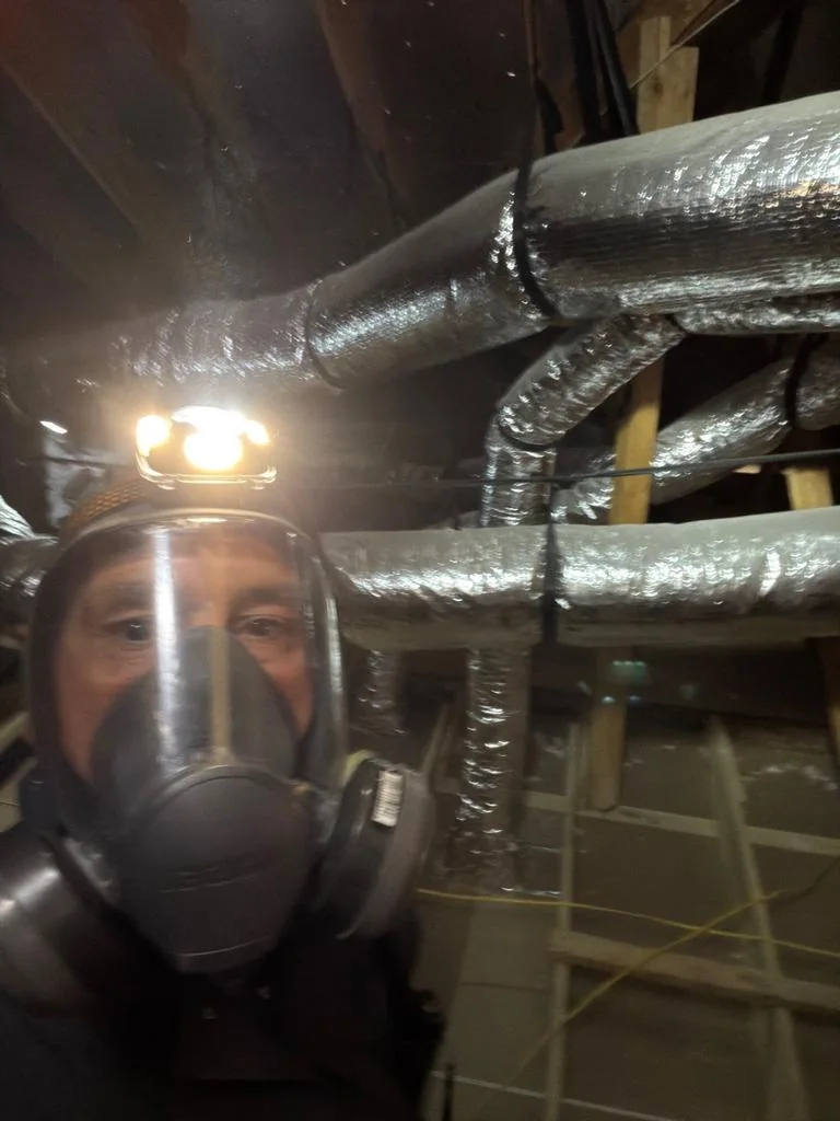 Rodent Control 2 20 Pest Me Off technician in a respirator working in a Frisco TX attic to remove rodents and check the runs